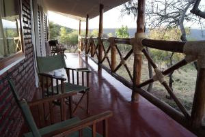 姆托瓦姆布African Sunrise Lodge and Campsite的房屋内的门廊配有桌椅