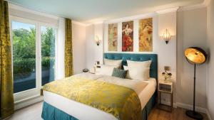 朗道因德普法尔茨朗达公园酒店的一间卧室设有一张床和一个大窗户