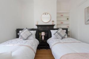 查塔姆The Mount 3 Bedroom Relaxation Home的配有2张床的白色墙壁和镜子