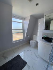 伦敦3 bed Apartment in Colliers Wood的一间带卫生间、水槽和窗户的浴室