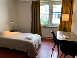 马尔默HOTEL N Hostel Malmö City的客房设有床、桌子和窗户。