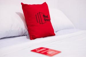 BumiayuRedDoorz Plus near Nagoya Hill Batam 6的红色枕头坐在红色块的床上