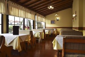 桑塔纳欧科尔莫酒店的用餐室设有桌椅和窗户。