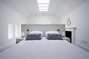 斯托诺韦Lews Castle的白色卧室配有一张带枕头的大白色床