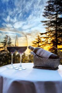 西姆拉Wildflower Hall, An Oberoi Resort, Shimla的桌子上放两杯红葡萄酒