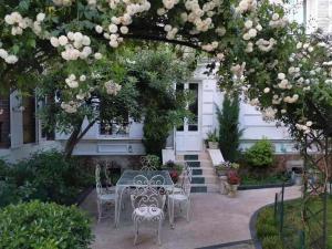 塞夫尔Appart luxueux 3+1 pcs avec jardin à 3 km de Paris的树下带桌椅的天井