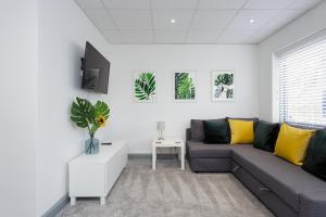 朴次茅斯Sovereign Gate - 2 double bedroom apartment in Portsmouth City Centre的客厅配有灰色的沙发和黄色的枕头。