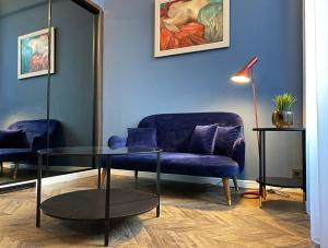 布达佩斯Hotel Rumor的客厅配有蓝色的沙发和玻璃桌