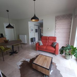 赫拉尔兹贝亨Holiday Apartment Al 't Sanna的客厅配有红色的沙发和桌子