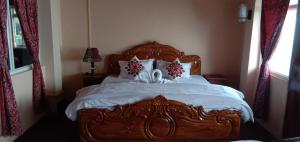 大吉岭RISE N SHINE HOMESTAY的一间卧室配有一张带白色床单和枕头的木制床。