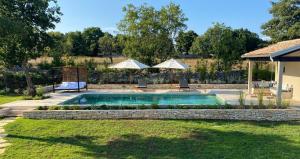 坎法奈尔Casa Conte Istria的一个带两把遮阳伞的庭院内的游泳池