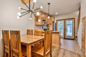 坎莫尔Banff Gate vacation townhouse的厨房以及带木桌和椅子的用餐室。