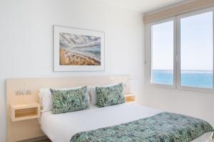 普拉亚布兰卡Blancazul Marina的白色的卧室设有床和窗户