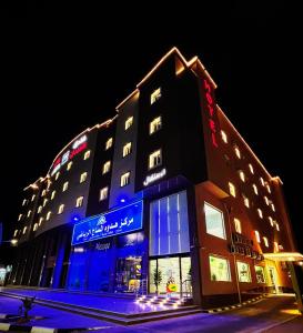 沙鲁拉فندق لامير إن Lamer in Hotel的建筑的侧面有蓝色的灯光