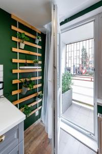科希策Flora Apartment Kosice Center的一间厨房,拥有绿色的墙壁和植物推拉门