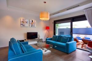 伊维萨镇Casa Lui的客厅配有蓝色椅子和电视
