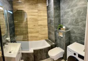 奥斯特罗达Apartament Kamila Ostróda的带浴缸、卫生间和盥洗盆的浴室