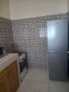 Sali TapéVilla Diambars的厨房配有冰箱和炉灶。