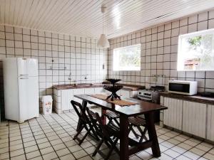 考卡亚Villa Oloh com lazer completo em Caucaia - CE的厨房配有桌椅和冰箱。