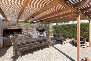 里戈尔Monte do Tanoeiro - Casa Tonel的一个带野餐桌和烧烤架的木制凉亭