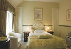 沙夫茨伯里鸢尾花酒店的卧室配有床、椅子和窗户。