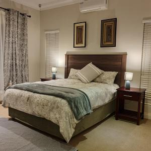 Albert FallsVerdant Valley Lodge的一间卧室配有一张大床,设有两个床头柜和两盏灯