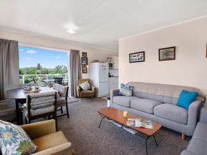 陶波Central Riverside Retreat - Taupo Holiday Home的客厅配有沙发和桌子