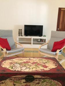 塞隆贝拉纳克武吉英达精品住宿加早餐旅馆的客厅配有两把椅子和电视