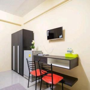 班昌Ek Residence Banchang City的带冰箱的客房配有一张桌子和两把椅子