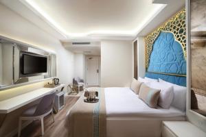 伊斯坦布尔Great Fortune Design Hotel & Spa的配有一张床和一张书桌的酒店客房