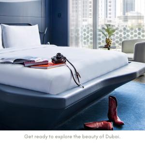 迪拜ME Dubai by Meliá的卧室配有带红色鞋的大型白色床
