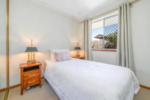 珀斯Layman Park Villa的卧室配有白色的床和窗户。