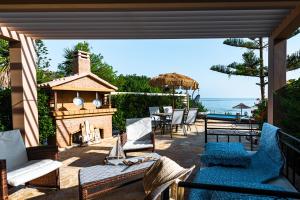 瓦西里科斯Beachfront Andriana Villa with mini pool and spa的一个带椅子和壁炉的庭院和大海