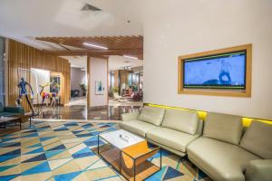 利雅德Ewaa Express Hotel - Al Olaya的带沙发和平面电视的客厅