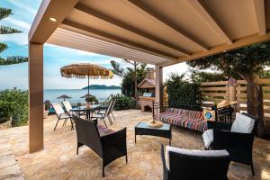 瓦西里科斯Beachfront Elena Villa with mini pool and spa的天井配有沙发和桌椅