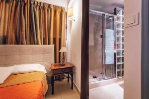 瓦西里科斯Beachfront Elena Villa with mini pool and spa的一间卧室设有一张床和一个玻璃淋浴间