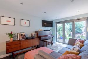剑桥Lovely Central Cambridge Home的带沙发和钢琴的客厅