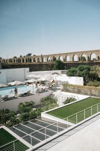 埃武拉马尔德尔阿克度托酒店的享有带游泳池和桥梁的建筑景致