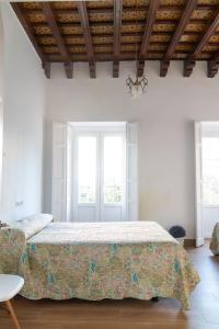 赫雷斯-德拉弗龙特拉Apartamentos El Alcazar de Jerez的一间卧室设有一张大床和两个窗户。