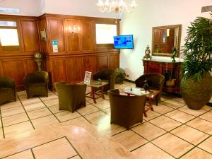 罗马玛格丽塔女王酒店的一间设有桌椅和电视的等候室