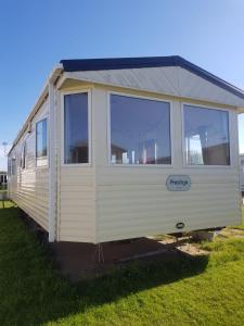 St Margarets at CliffPrivate caravan situated at Parkdean Holiday Resort St Margaret's at Cliffe number 18的坐在草地上的白色小房子