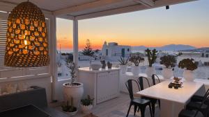 米克诺斯城Elaia Luxury Suites Mykonos的市景阳台配有桌椅。