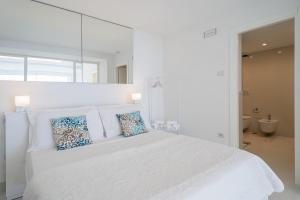 卡普里Casa Capri Me的白色卧室配有白色大床和蓝色枕头