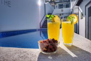 富尔纳斯Vale dos Encantos的池畔桌子上放着两杯饮料和一碗水果