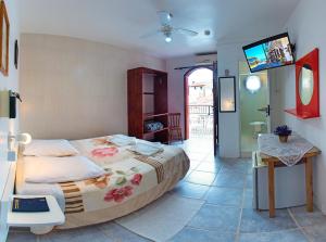 加罗帕巴路宝酒店的一间卧室配有一张床和一台电视