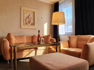 巴登-巴登Hotel Quellenhof的客厅配有沙发和桌椅