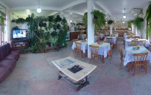 加罗帕巴路宝酒店的餐厅设有桌椅、电视和植物