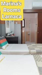 拉纳卡Marina's Rooms Xrisopolitissa Larnaca的一间带两张床铺的卧室,位于带镜子的房间内