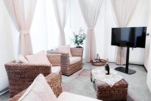 科莫Historical Suites - The House Of Travelers的客厅配有藤椅和平面电视