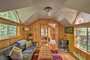 阿什福德Elk Hideaway Ashford Cottage with Hot Tub!的客厅设有真皮沙发和壁炉